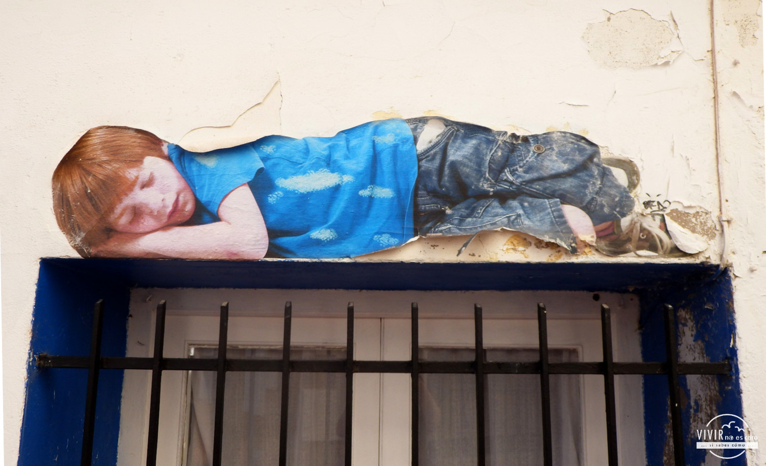 Graffiti de niño dormido sobre una ventana en Fanzara (Castellón)