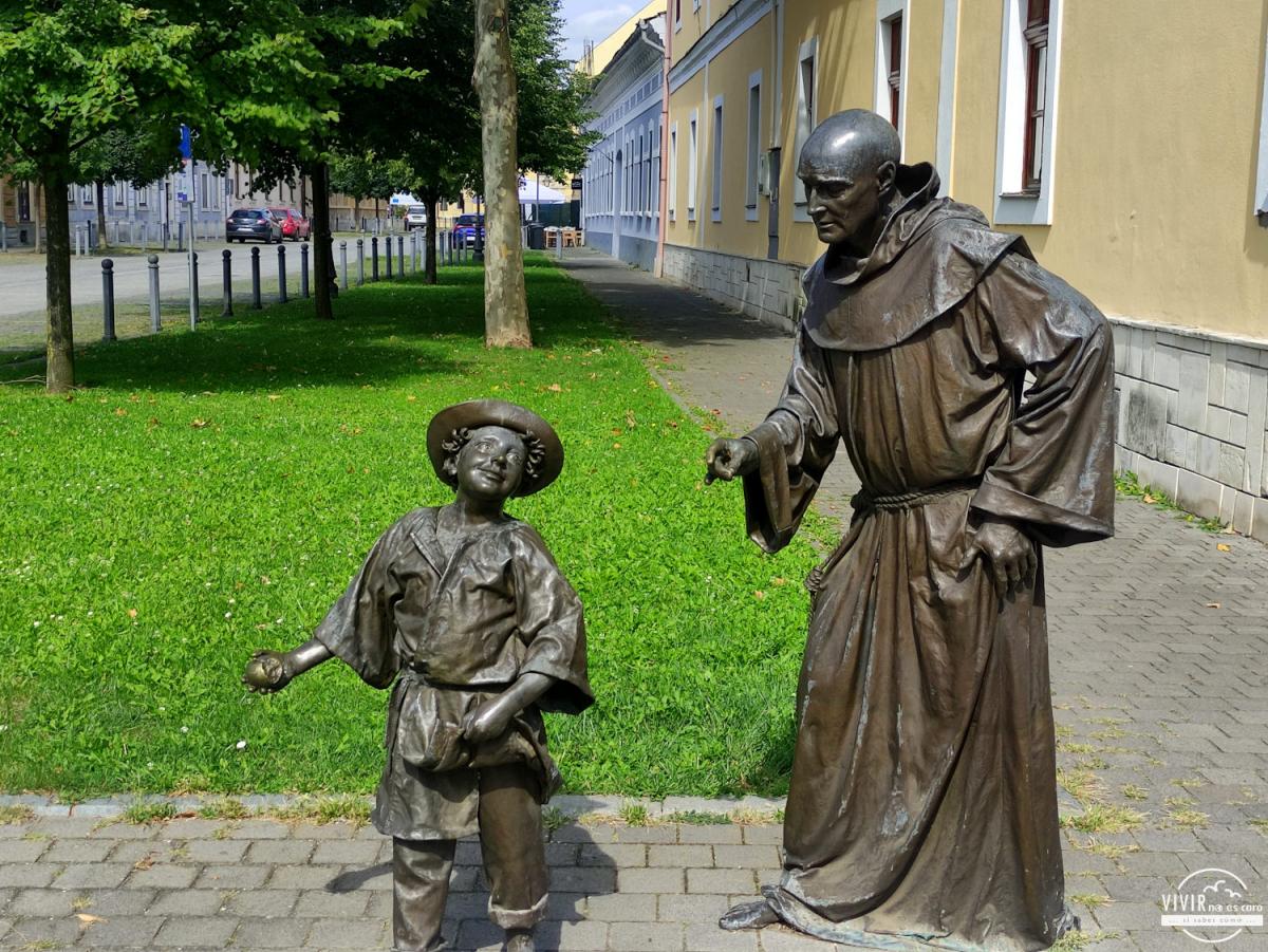 Escultura de bronce de niño y un cura (Alba Carolina, Rumanía)